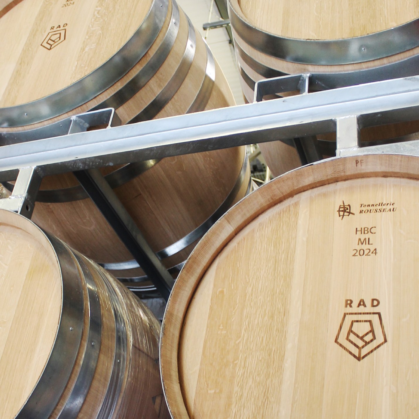 French oak barrels stamped with the RAD logo, racked in the winery